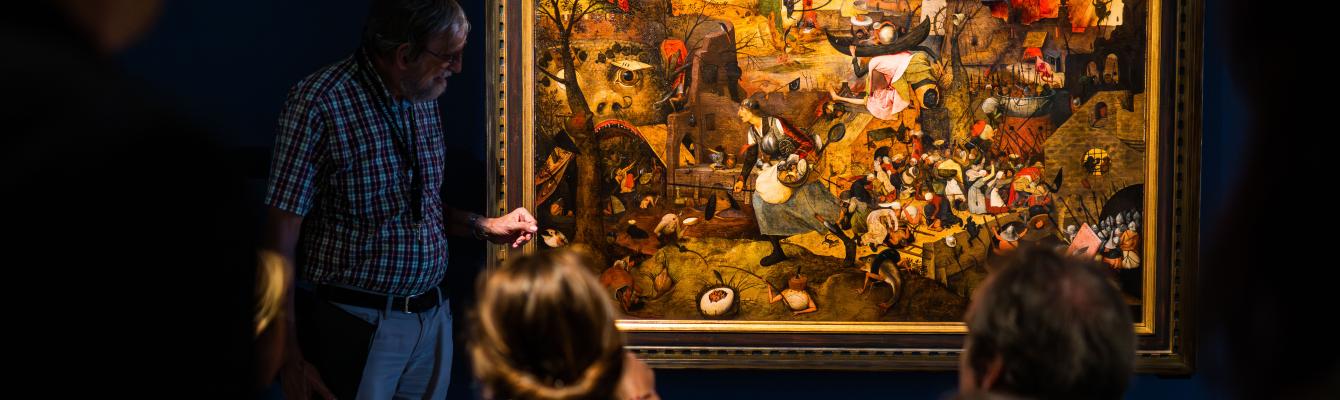 Mensen kijken naar het schilderij 'Dulle Griet' van Pieter Bruegel de Oude.