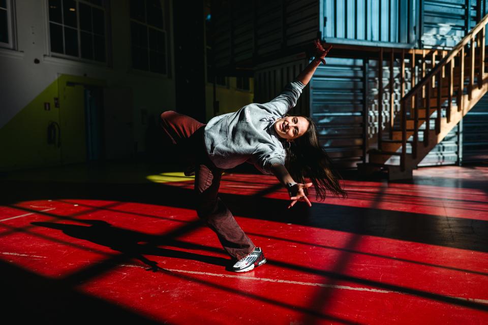 Een jonge vrouw is aan het breakdancen.