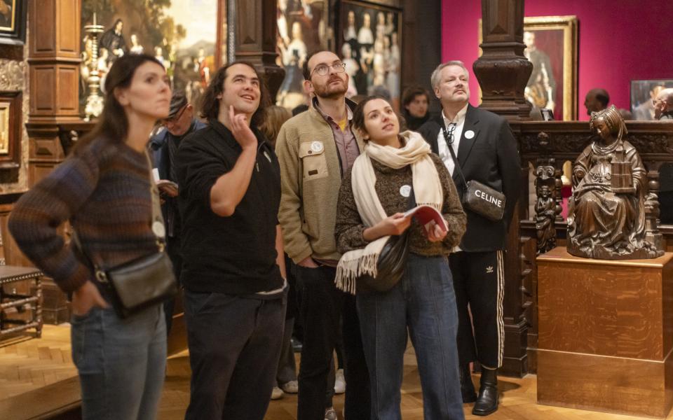 Groepje bezoekers kijken aandachtig naar een kunstwerk 