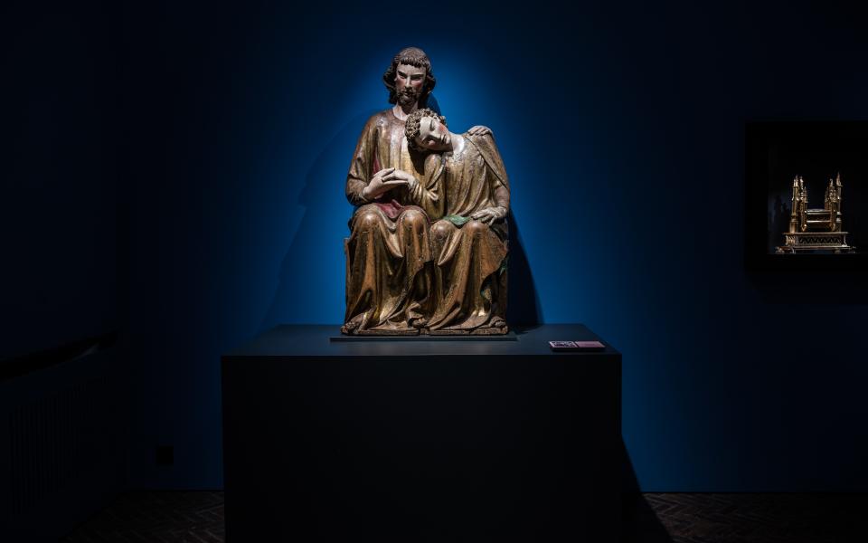 Een houten sculptuur van Johannes die zijn hoofd laat rusten op de schouder van Jezus.