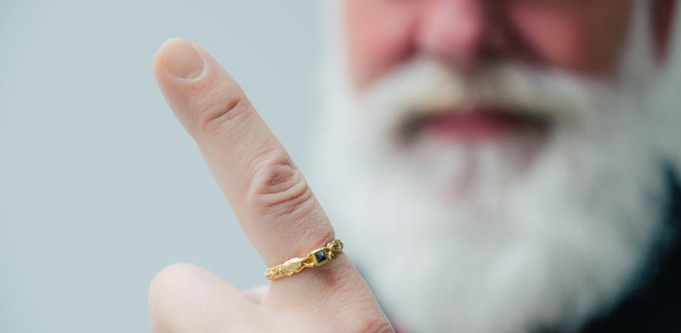 Een man toont trots zijn wijsvingerring.