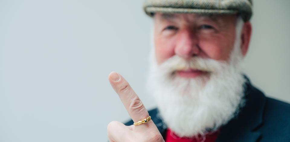 Een man toont trots zijn wijsvingerring.