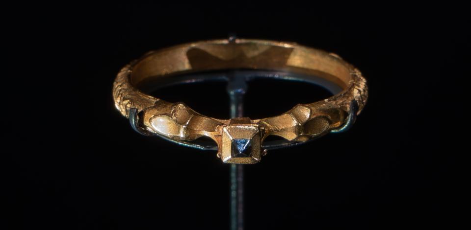 Foto van een eeuwenoude gouden ring met zwarte diamant in piramidevorm.
